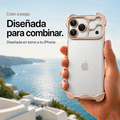 Champagne gold sculpted metal phone case held in a hand above a coastal background #color_Champagne Gold