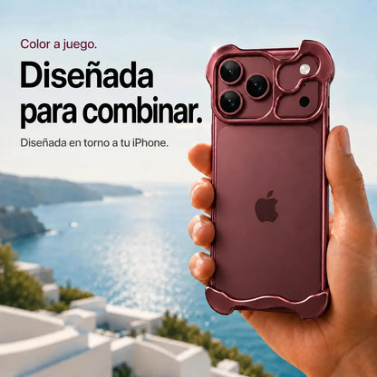 Burgundy sculpted metal phone case held above a coastal background #color_Burgundy