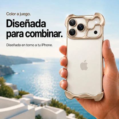 Sand gold sculpted metal phone case held in a hand above a coastal background #color_Desert Gold